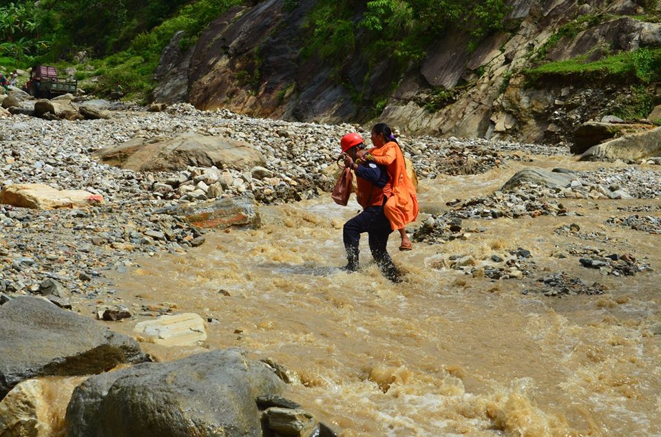 जाजरकोटको पासागाड खोलामा फसेको गाडी र यात्रुको उद्धार गदै प्रहरी